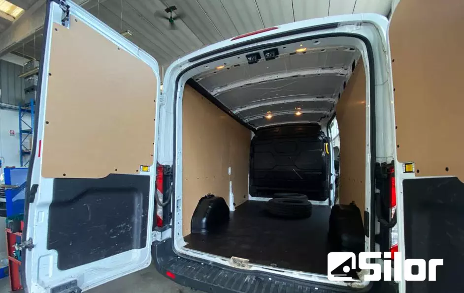 Interni di un furgone merci bianco con le porte posteriori aperte.