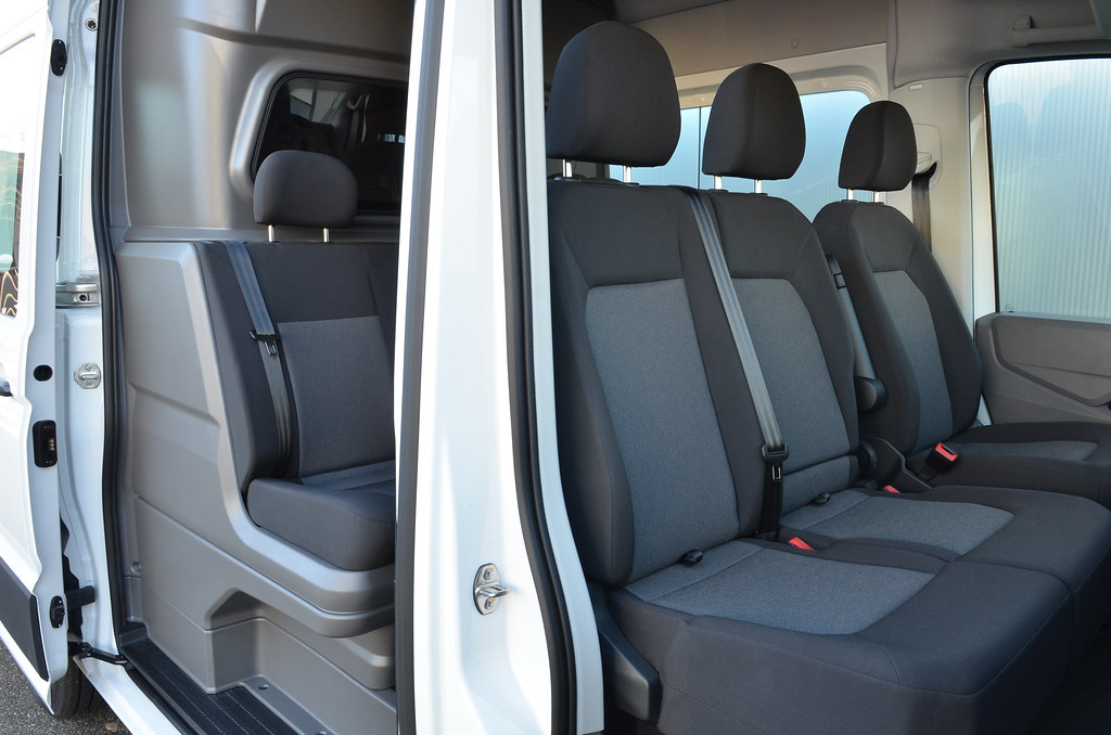 Interni di un furgone bianco con sedili in tessuto grigio.
