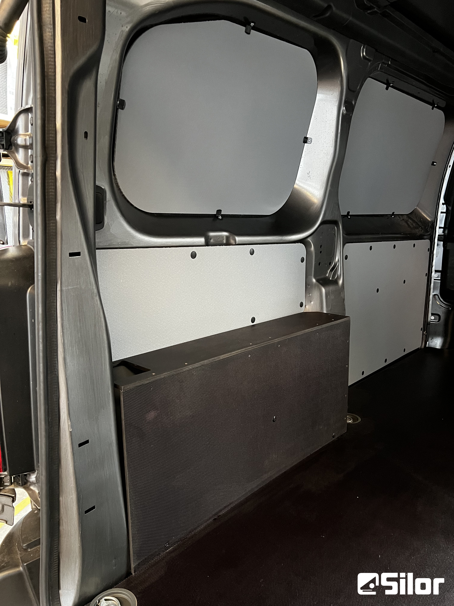 Interni di un furgone commerciale con protezione delle pareti grigie e scatola nera.