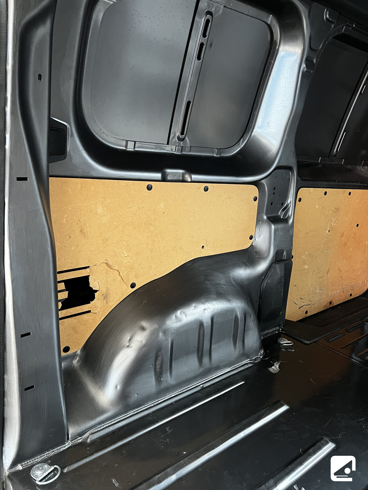 Interni di un furgone nero con pannelli in legno.