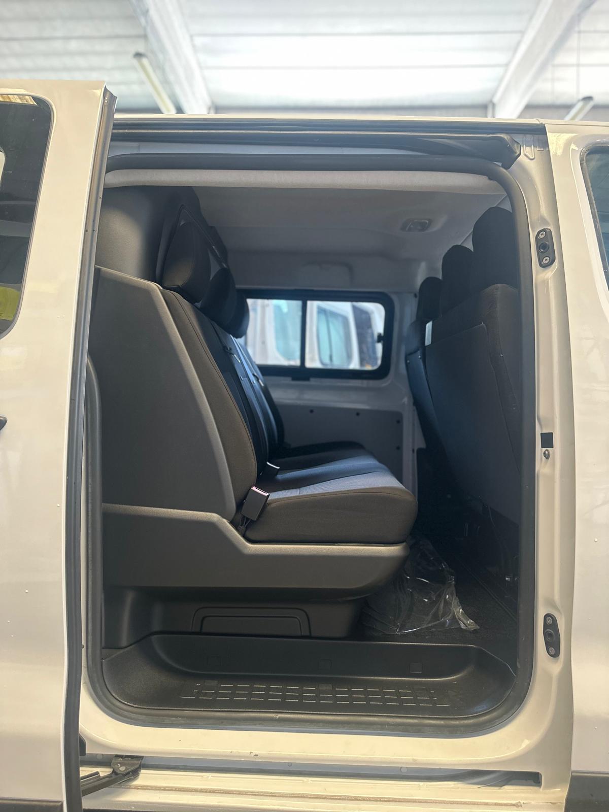 Interni di un furgone bianco con sedili grigi.