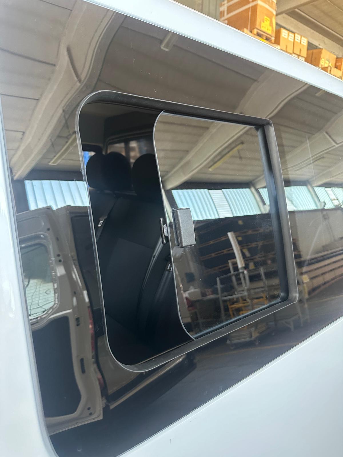 Finestrino laterale scorrevole di un furgone bianco.