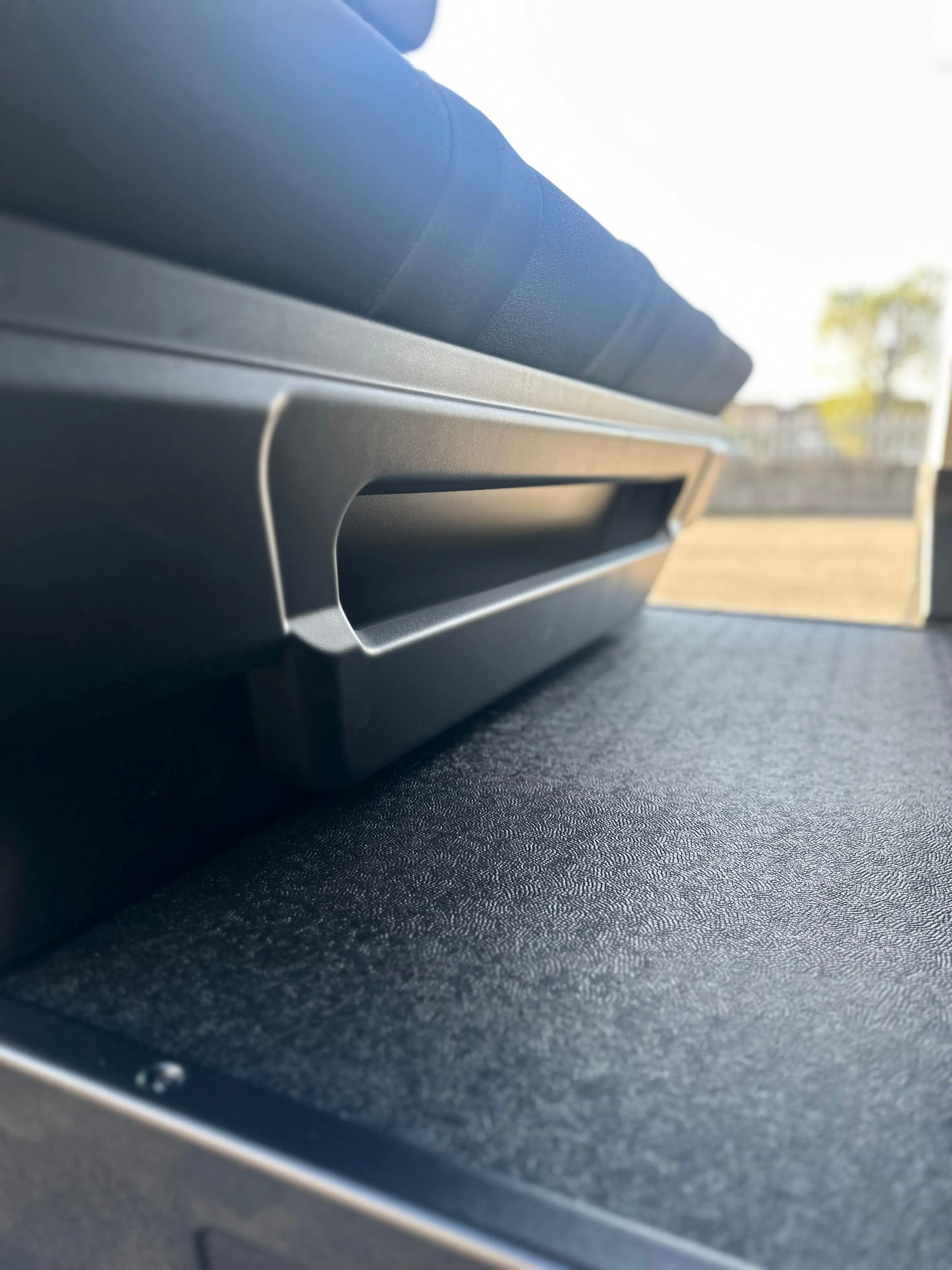 Interni di un furgone camperizzato con letto e spazio di stoccaggio.