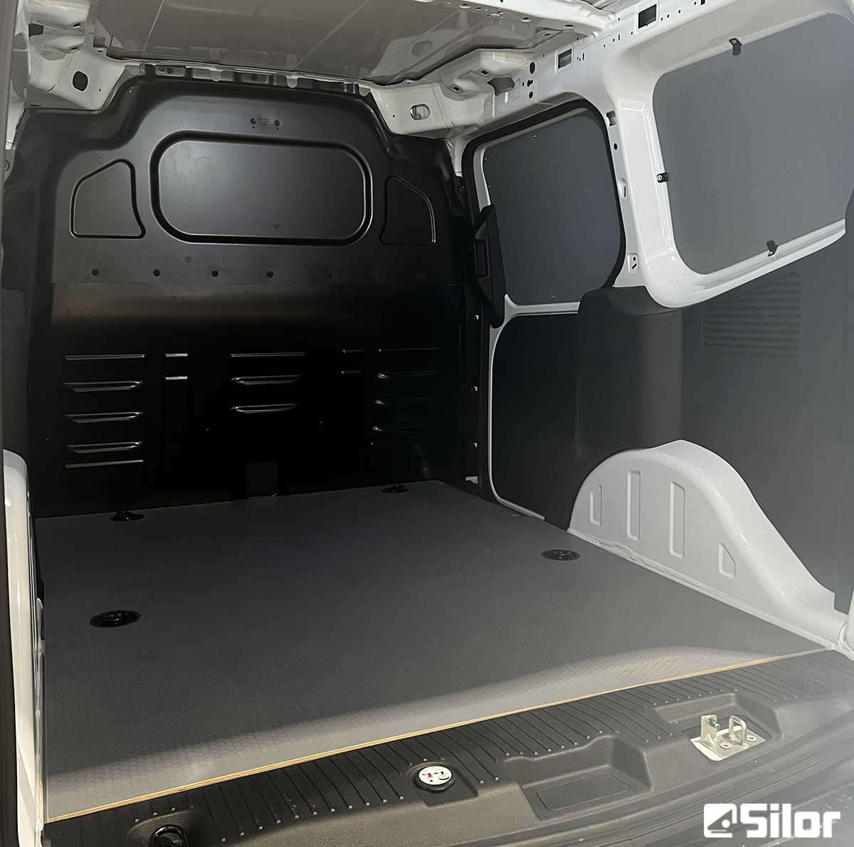 Interno di un furgone cargo con pianale e pareti protettive.