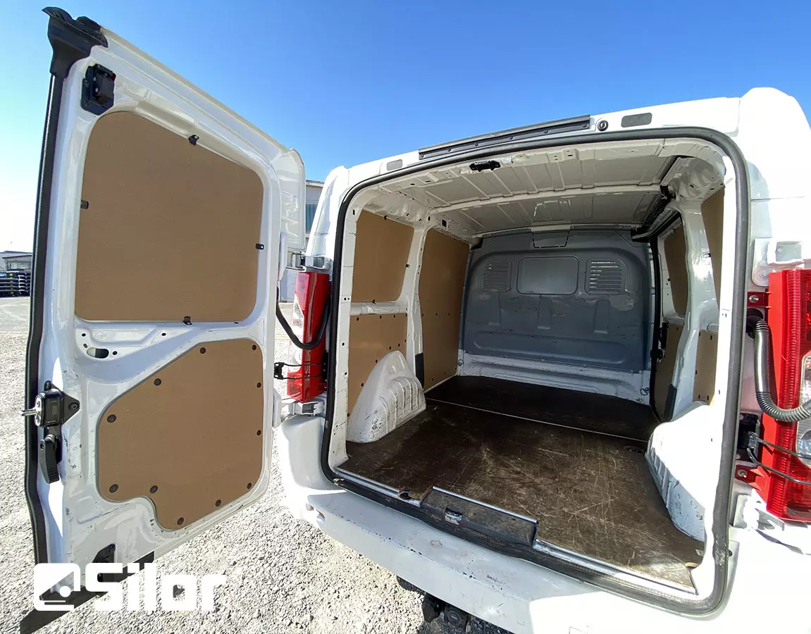 Interni di un furgone bianco con portiere posteriori aperte.