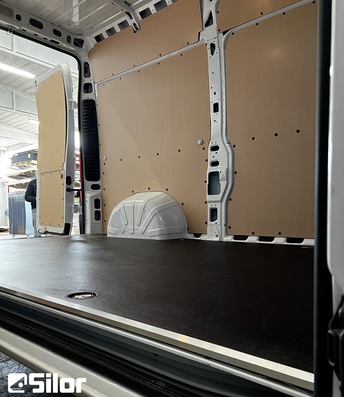 Interni di un furgone allestito con pannelli in legno e pavimento antiscivolo.