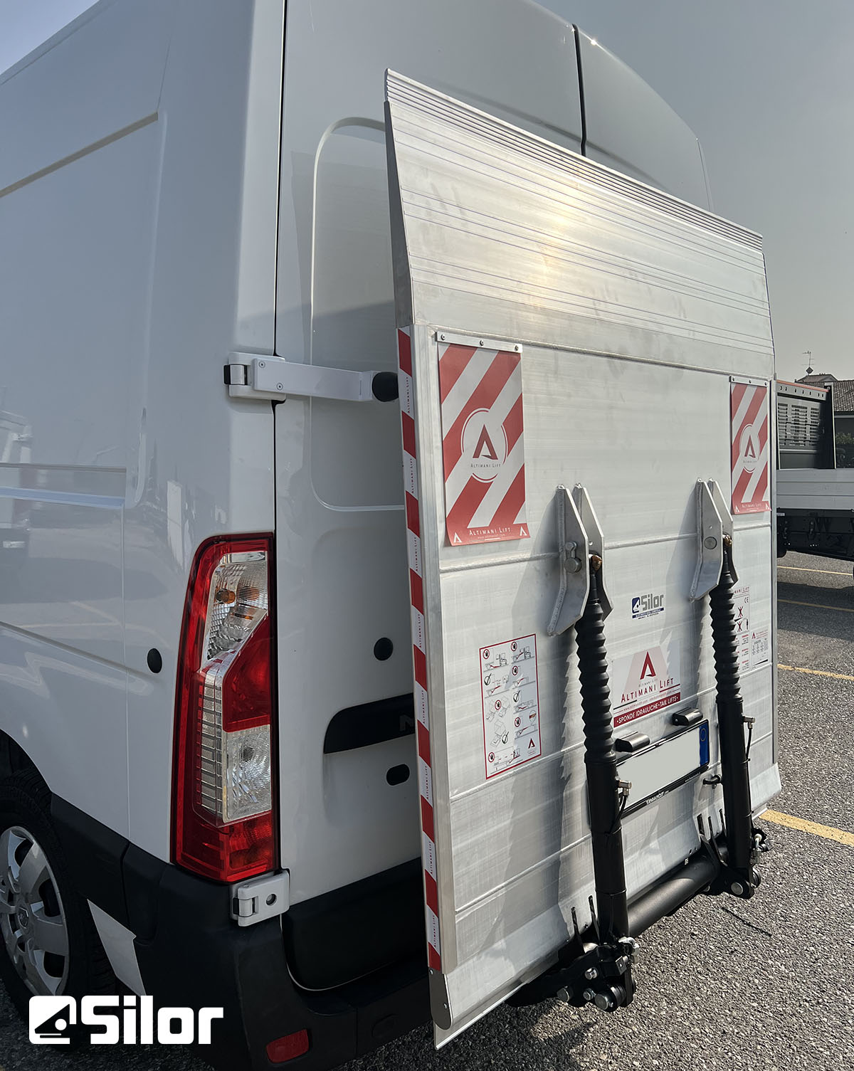 Furgone bianco con sponda montacarichi in alluminio.