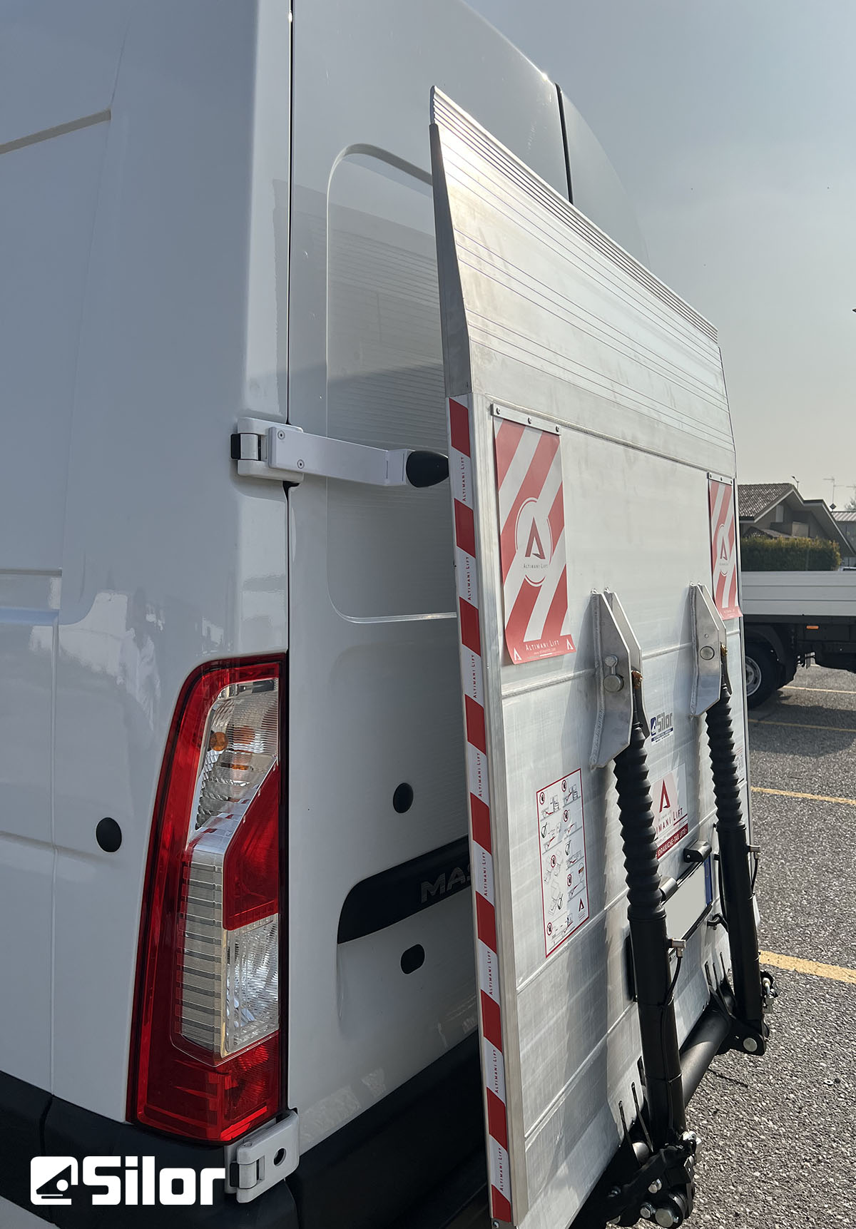 Un furgone bianco con rampa di carico e logo Silor.
