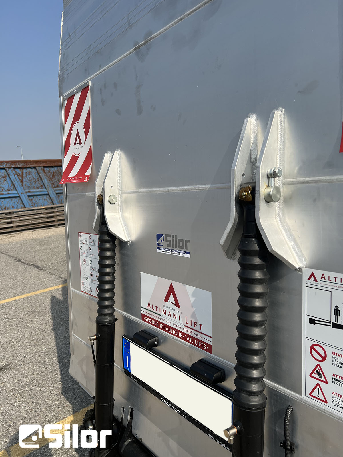 Vista ravvicinata delle gambe di sostegno di un camion con i marchi del produttore.