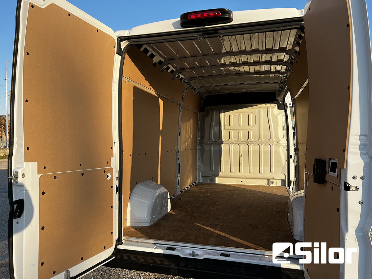 Interni di un furgone bianco con porte posteriori aperte.