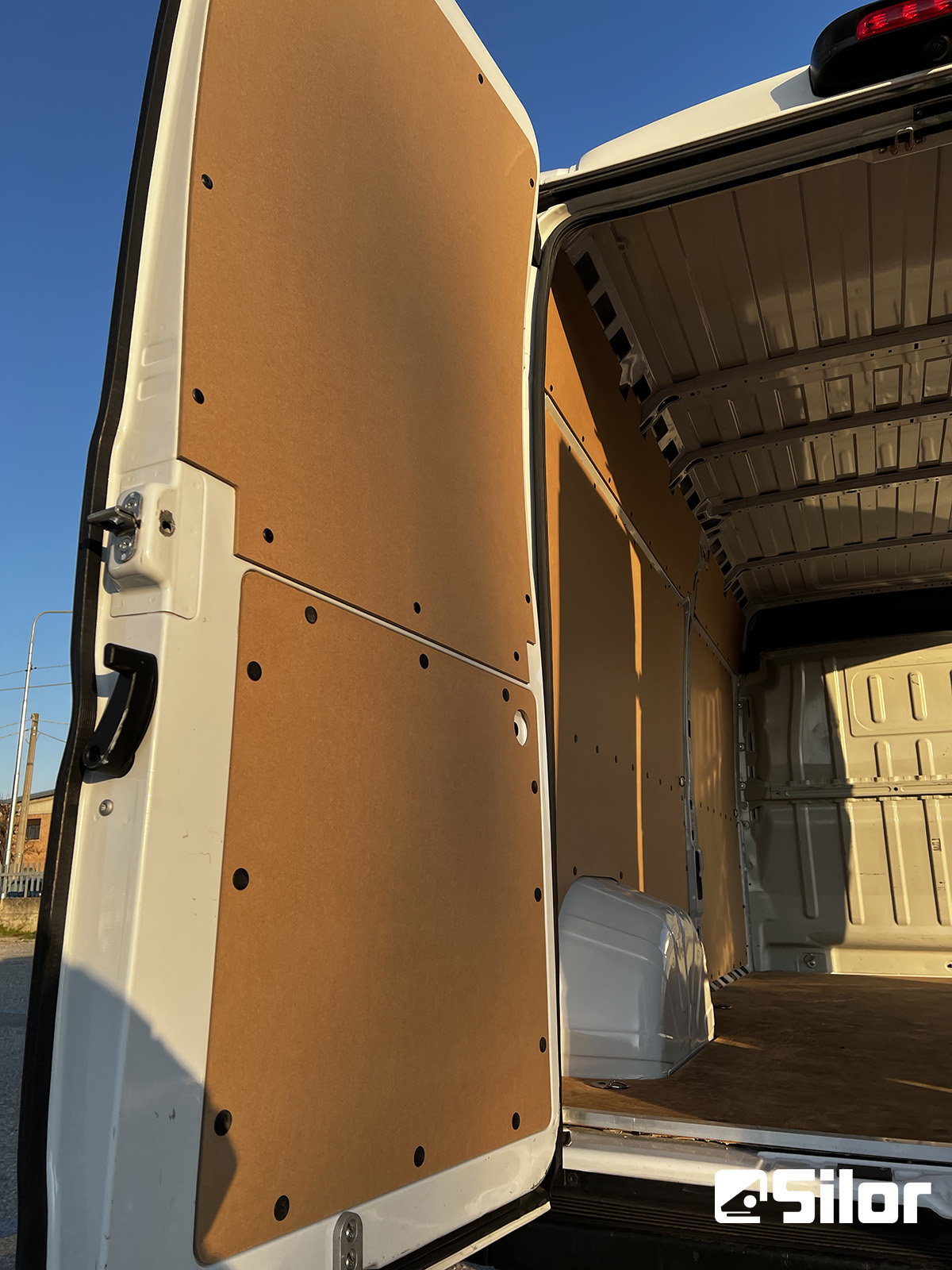 Interno di un furgone commerciale con le porte posteriori aperte.