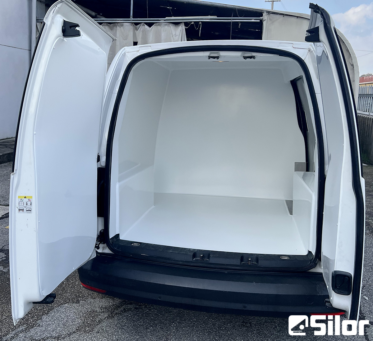 Interni luminosi e spaziosi di un furgone bianco.