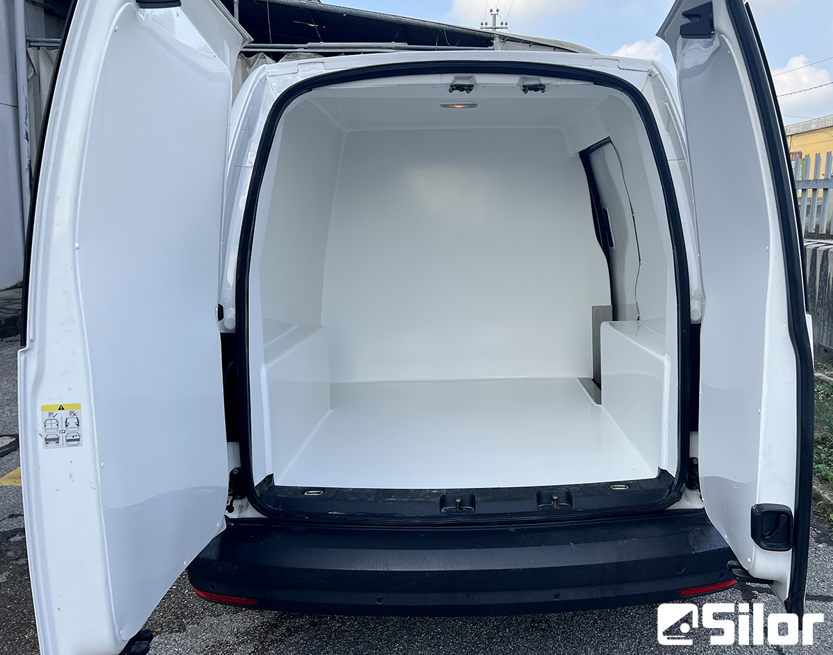 Un furgone bianco con le portiere posteriori aperte che mostrano l'interno.