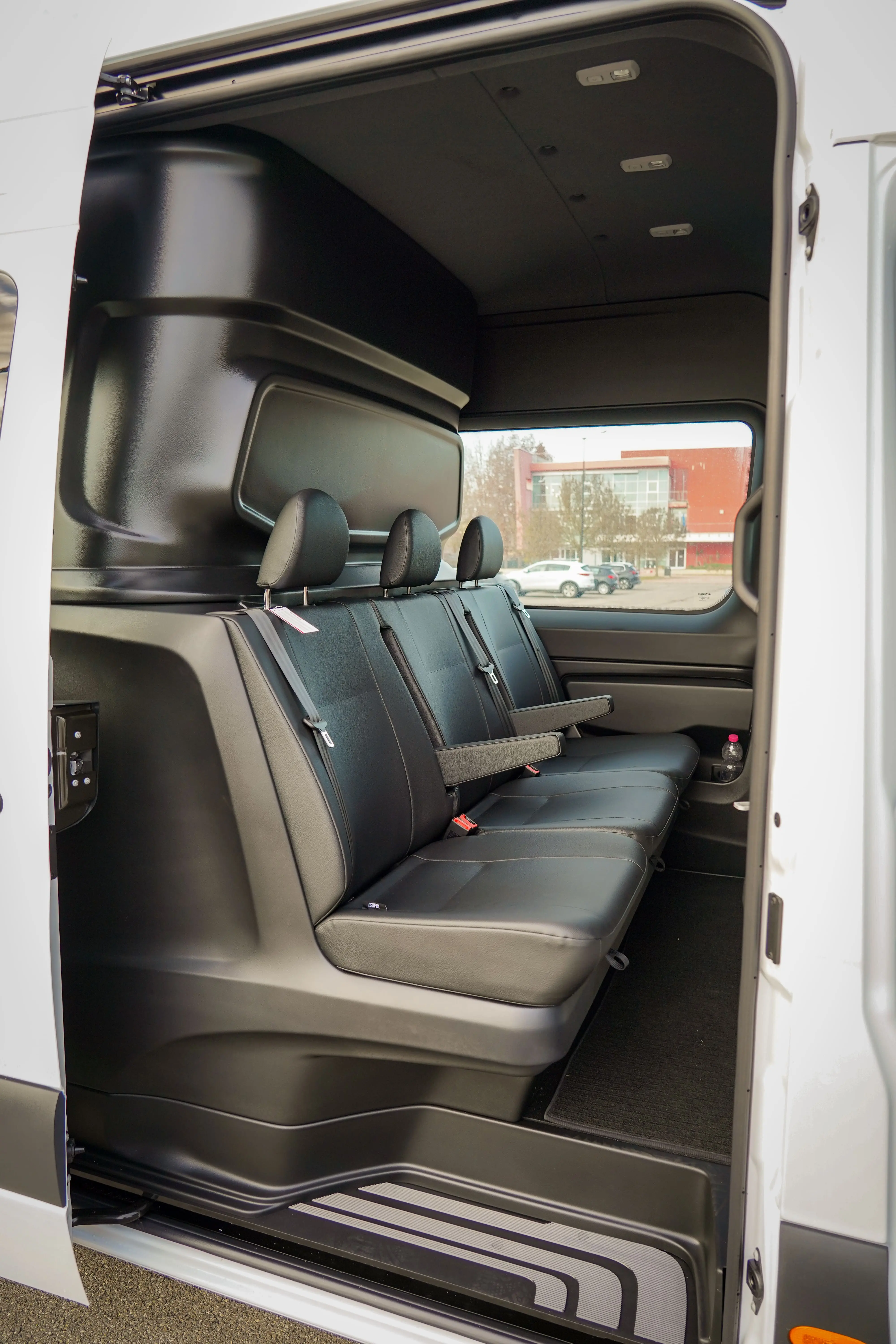 Interni di un furgone con tre sedili neri.