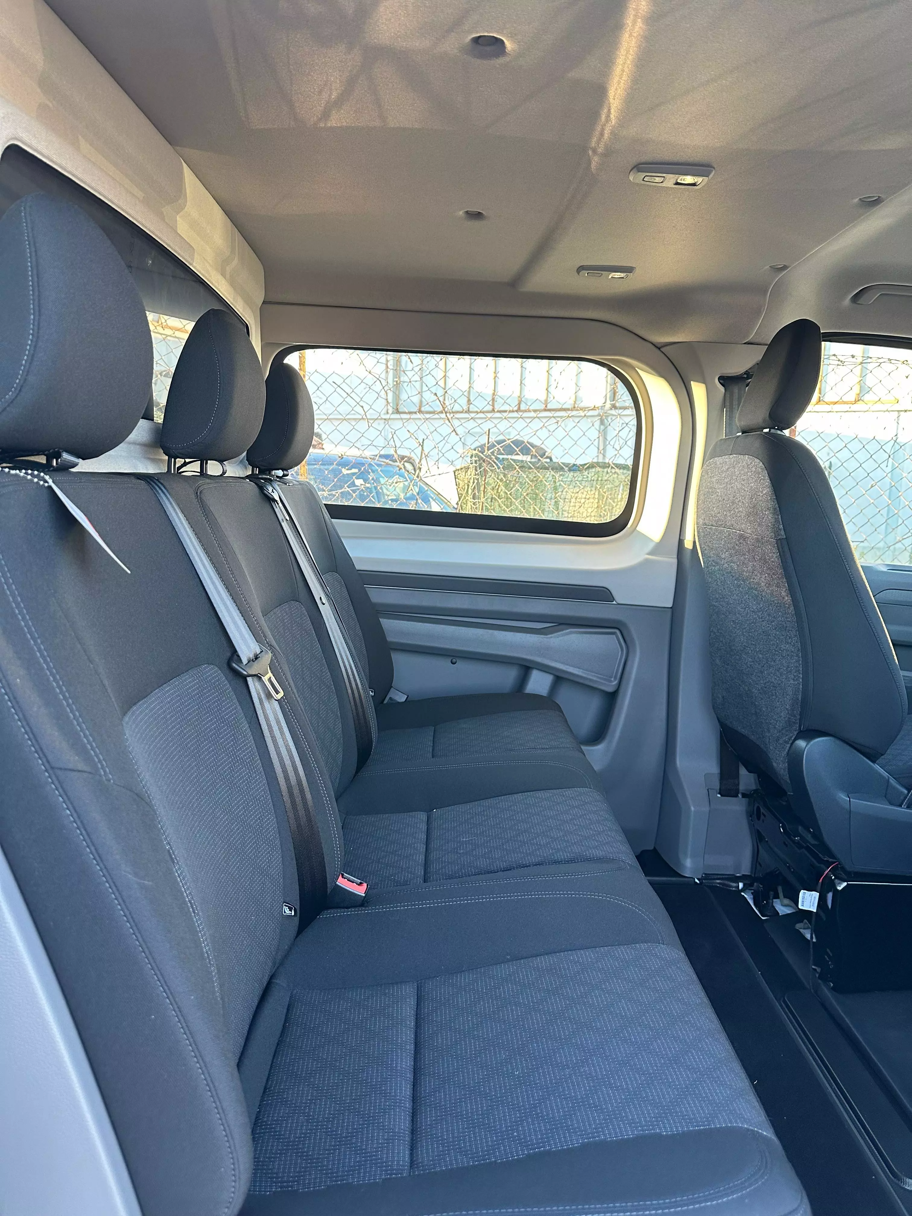 Interni di un furgone passeggeri con sedili in tessuto blu.