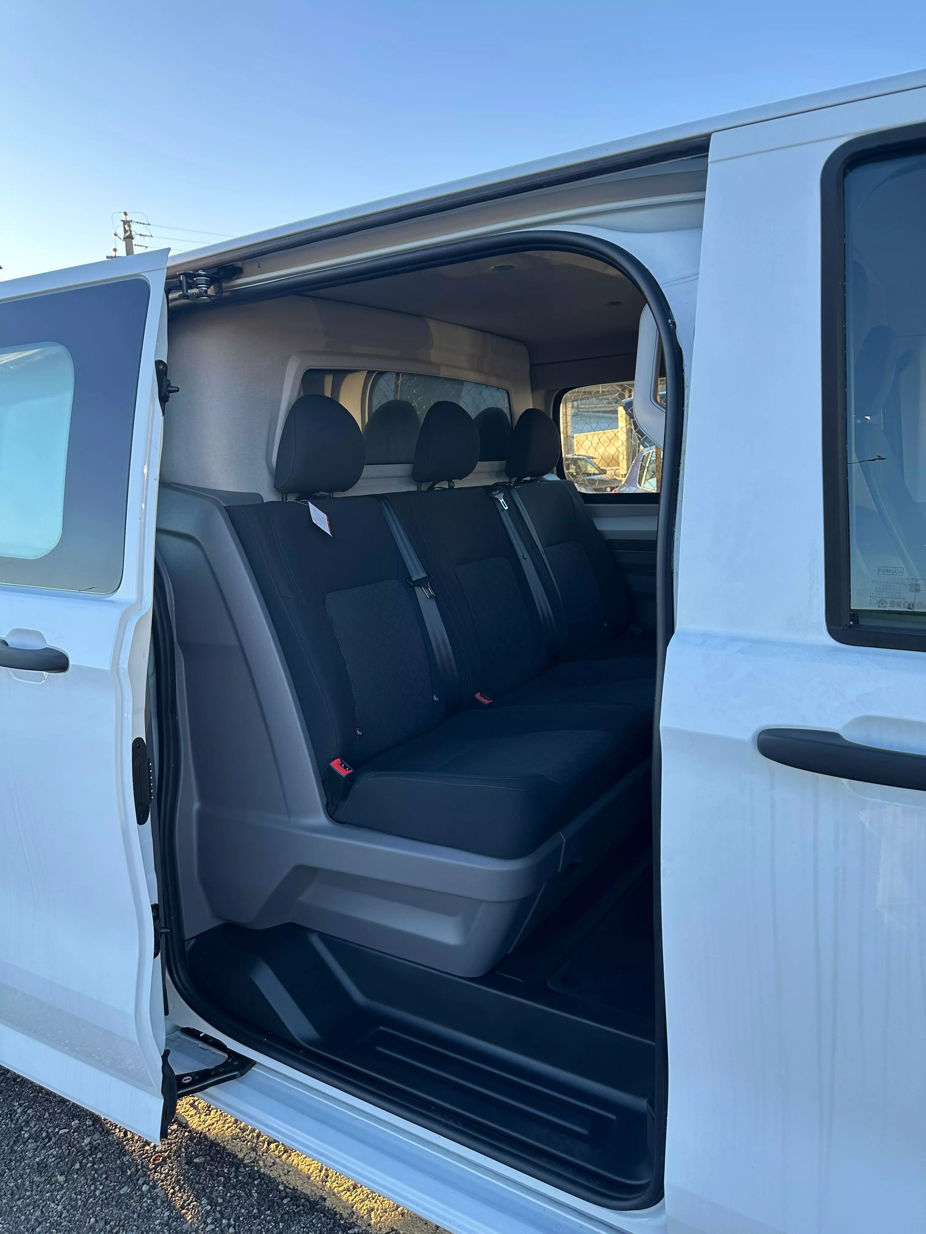 Interni di un furgone bianco con sedili posteriori neri.