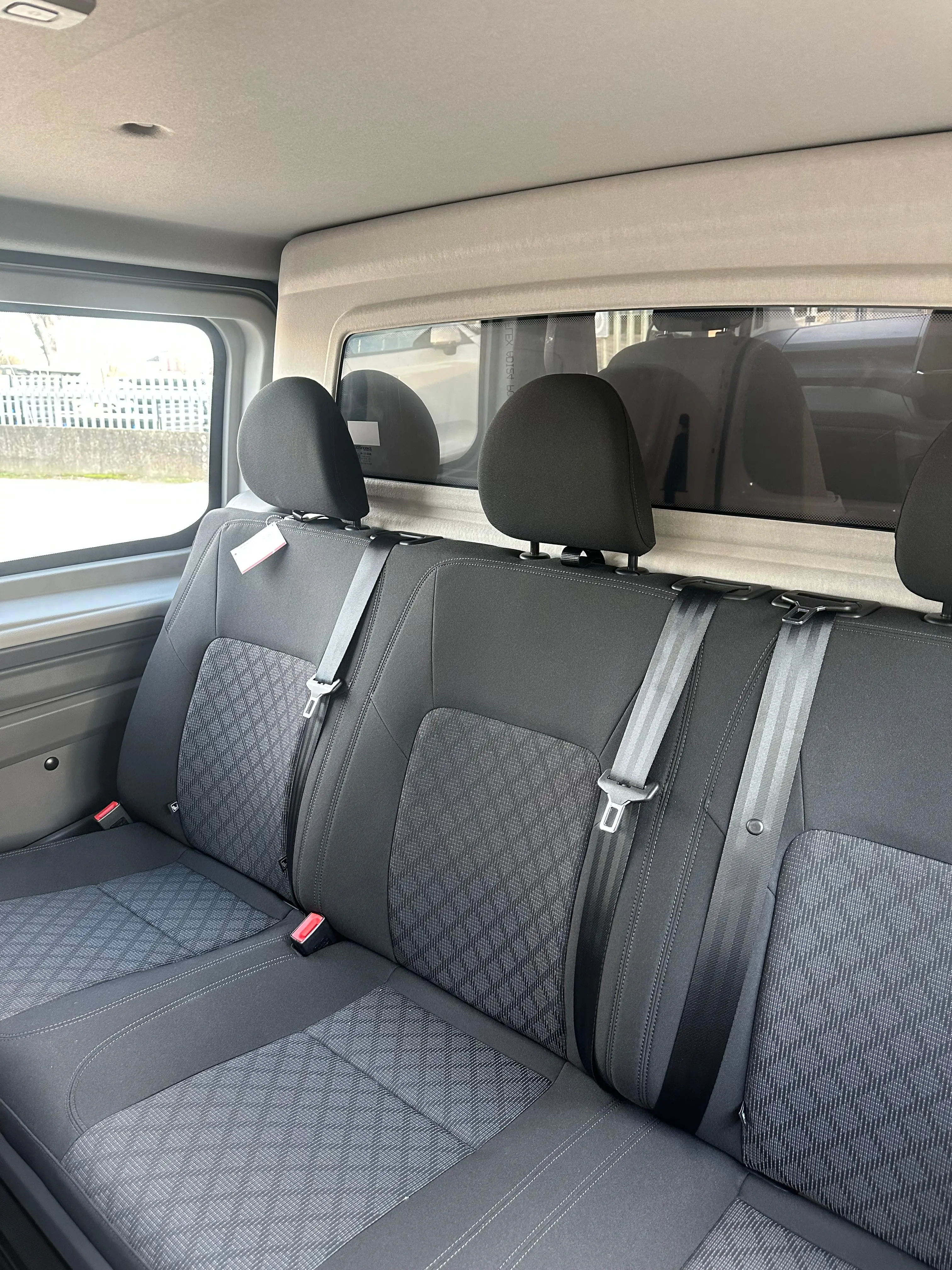 Interno di un'auto con sedili posteriori grigi.