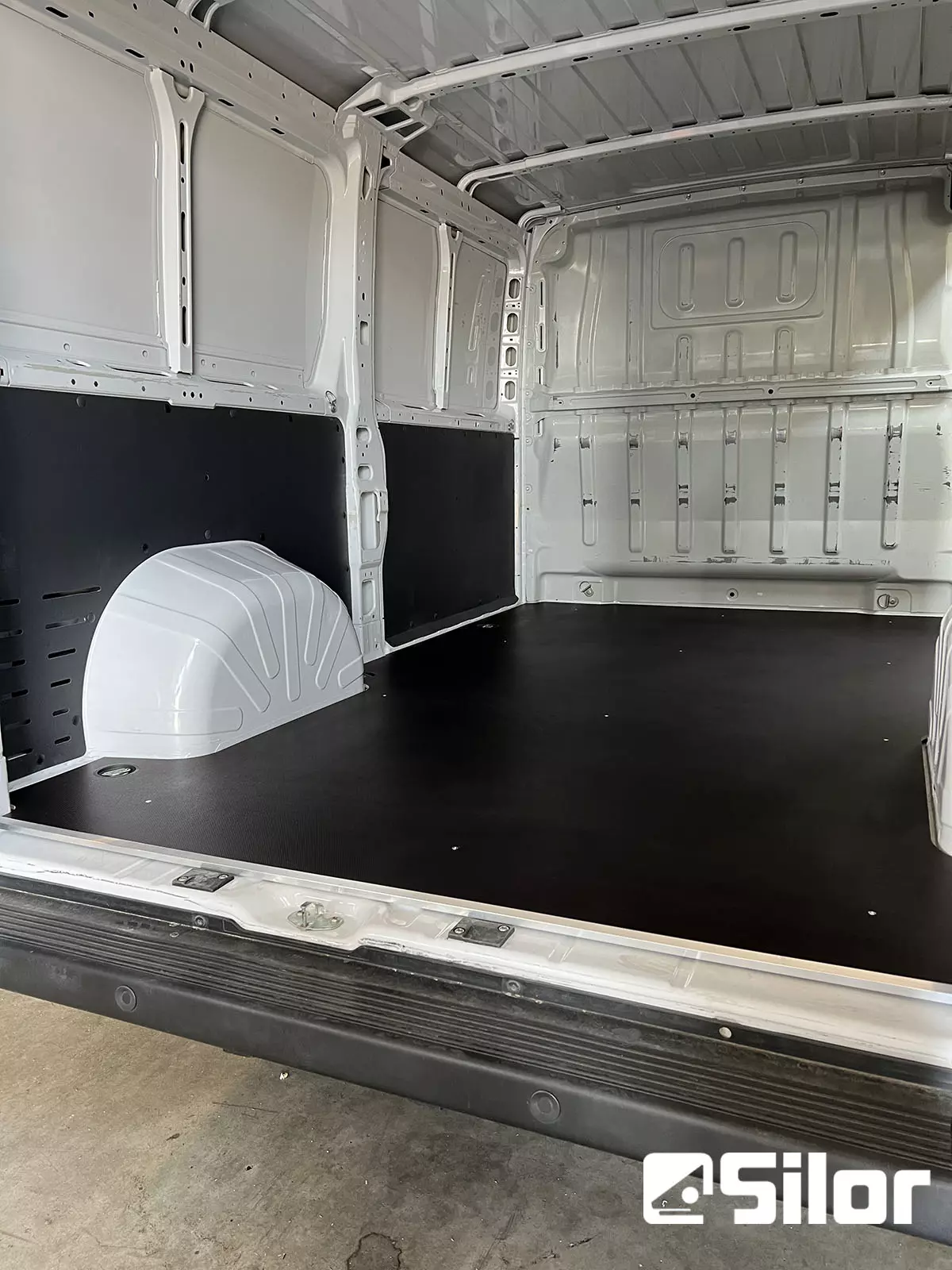 Interni di furgone bianco con pavimento e pannelli neri.