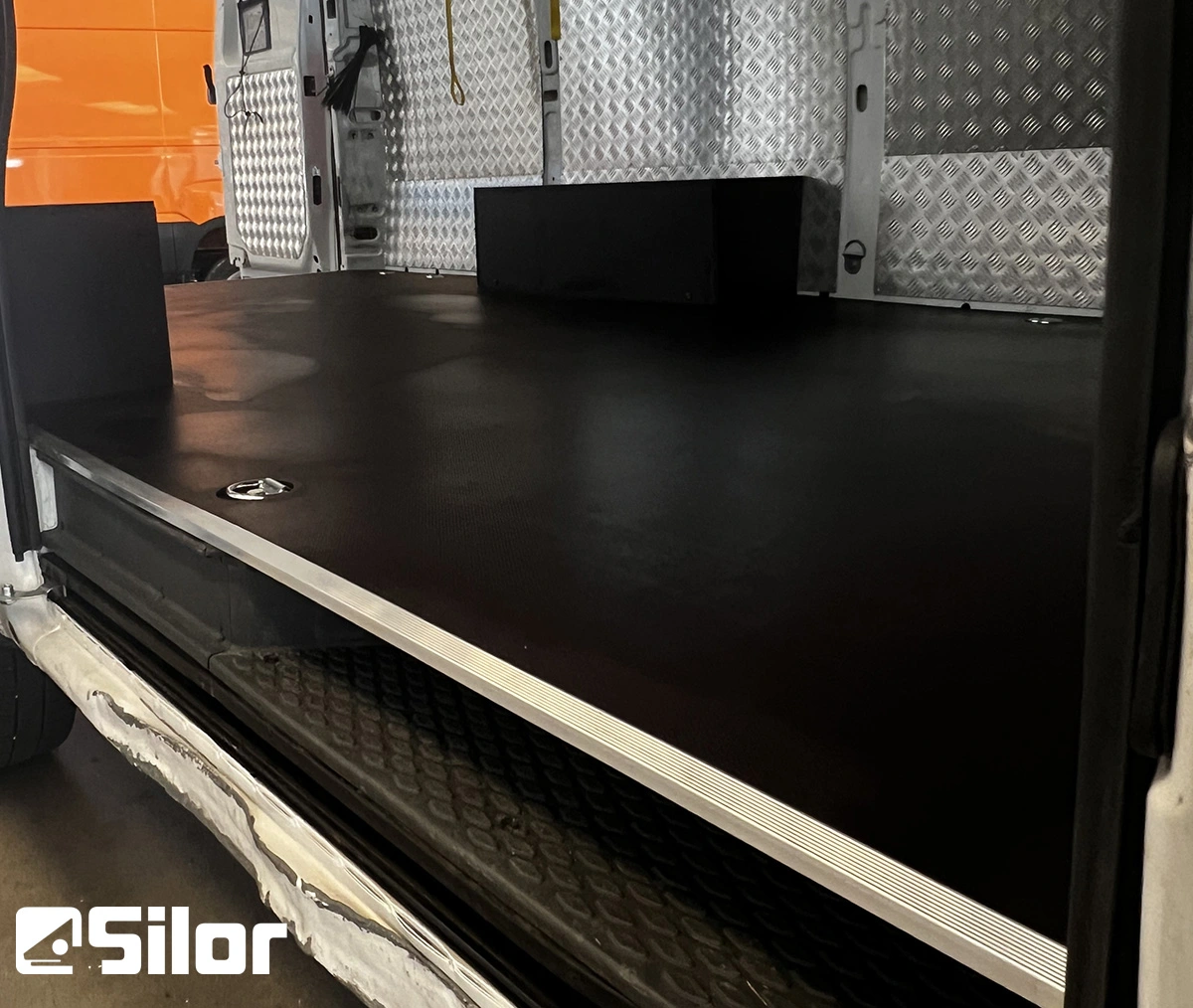 Interno di un furgone commerciale con pavimento in gomma nera.