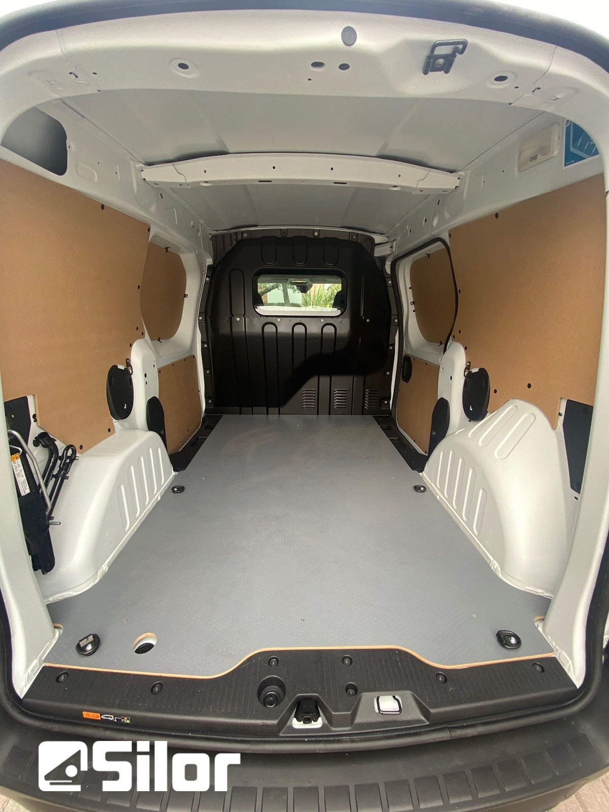 Interni di un furgone commerciale, con rivestimento in legno sui lati.