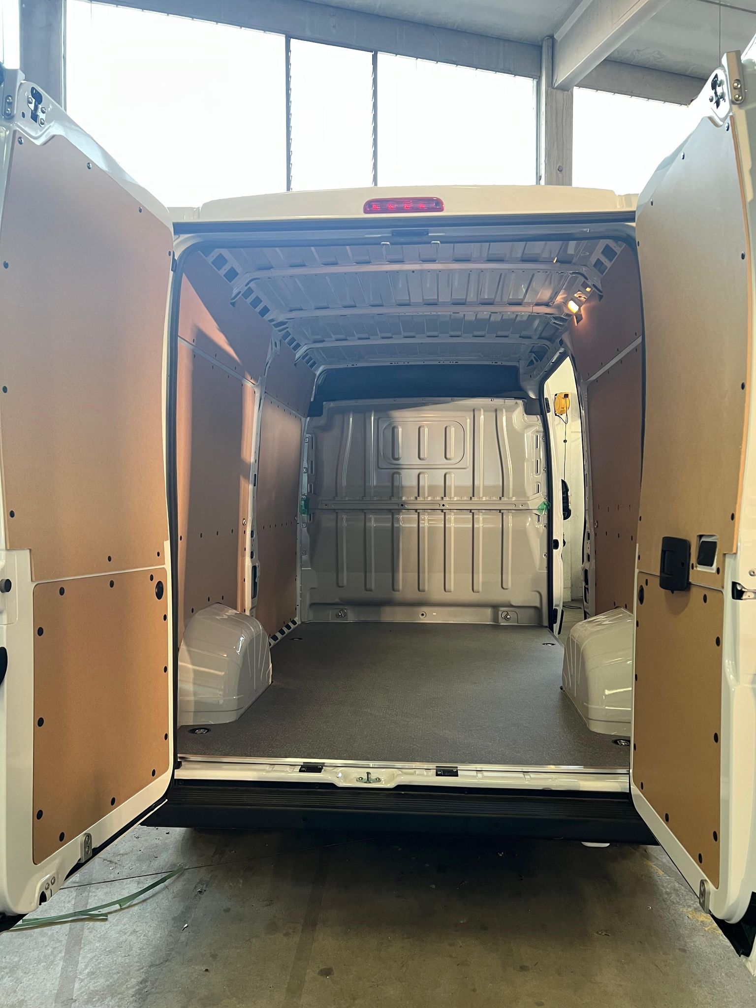 Interni di un furgone bianco con porte posteriori aperte.
