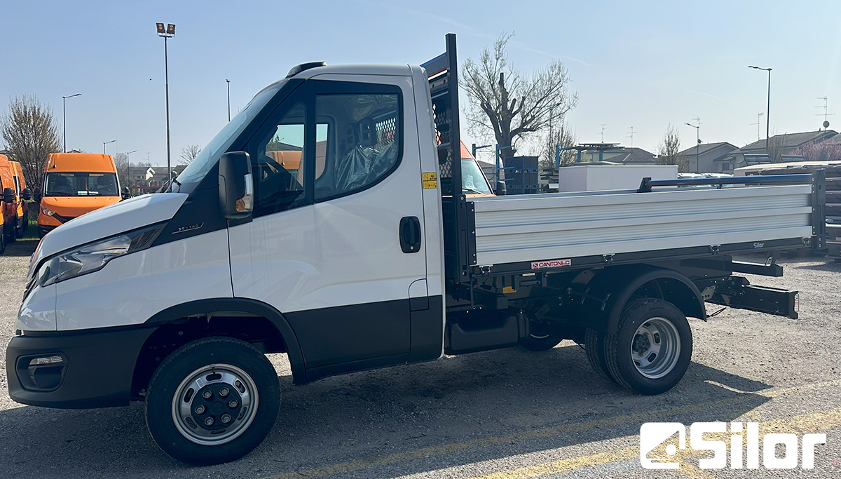 Camion Iveco bianco con cassone ribaltabile.
