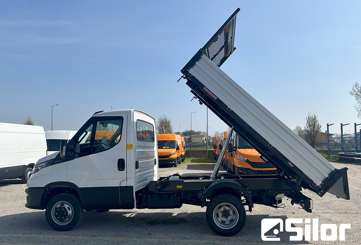 Camion ribaltabile Iveco bianco con cassone rialzato in mostra.
