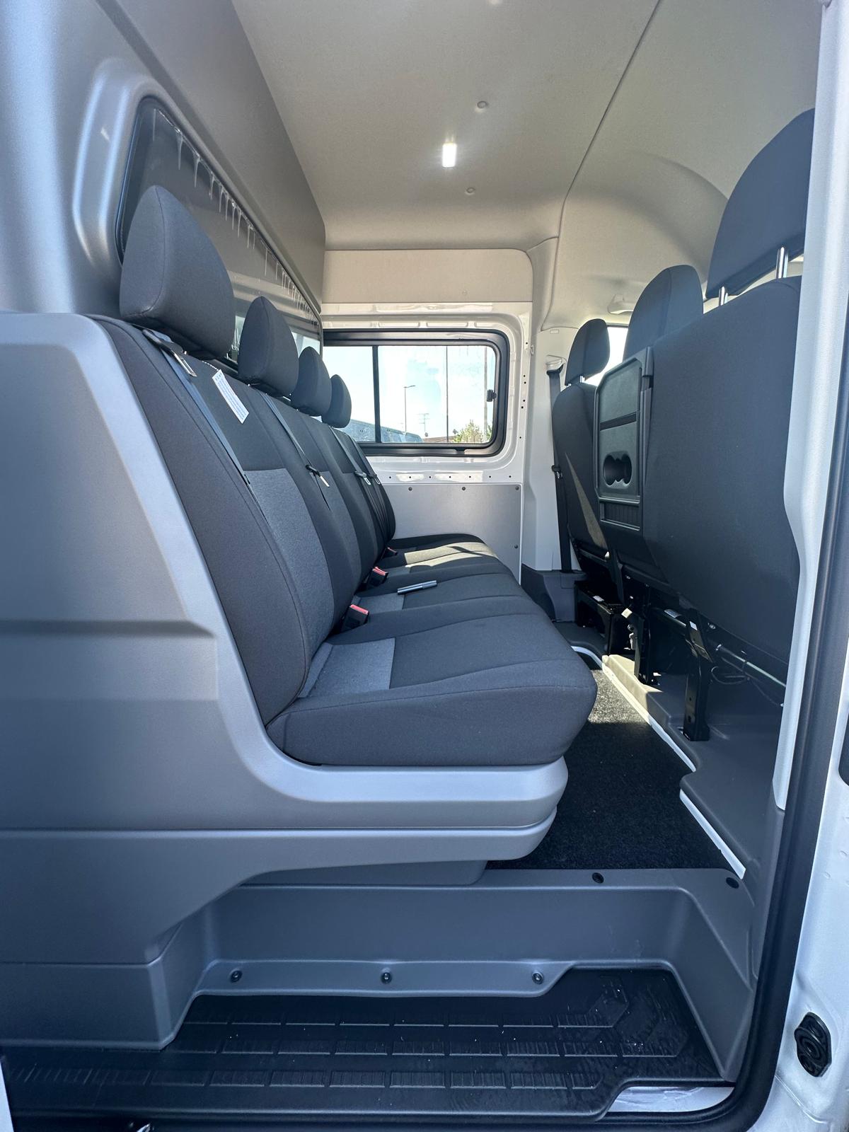 Interno spazioso di un furgone per passeggeri con sedili grigi.