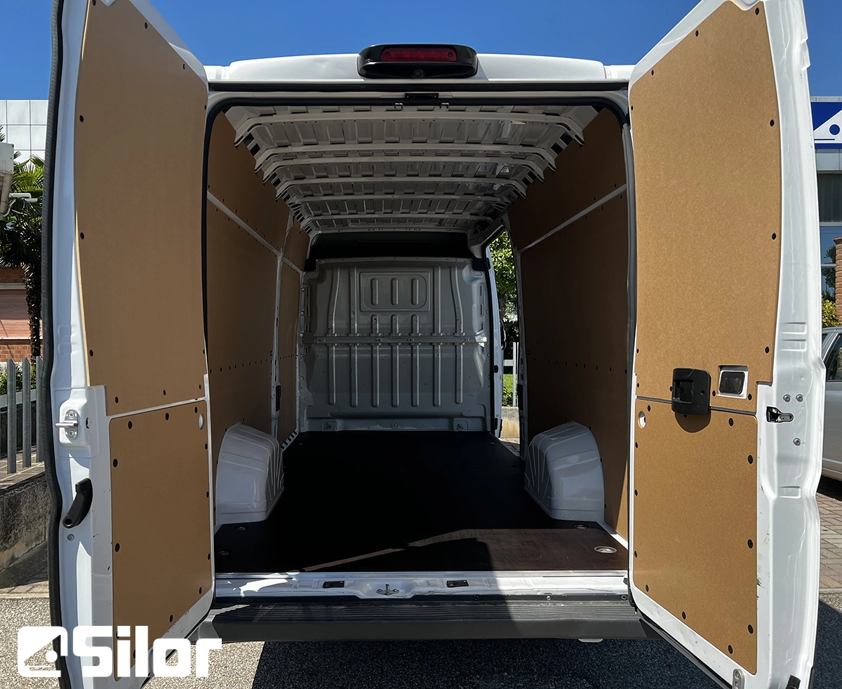 Interni di un furgone bianco con le porte posteriori aperte.