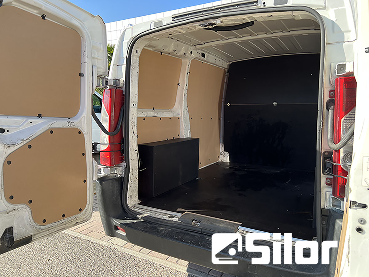 L'interno di un furgone bianco con porte posteriori aperte.