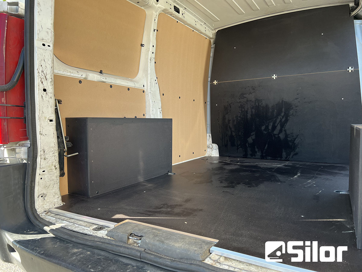 Interno di un furgone merci con pannelli di legno.