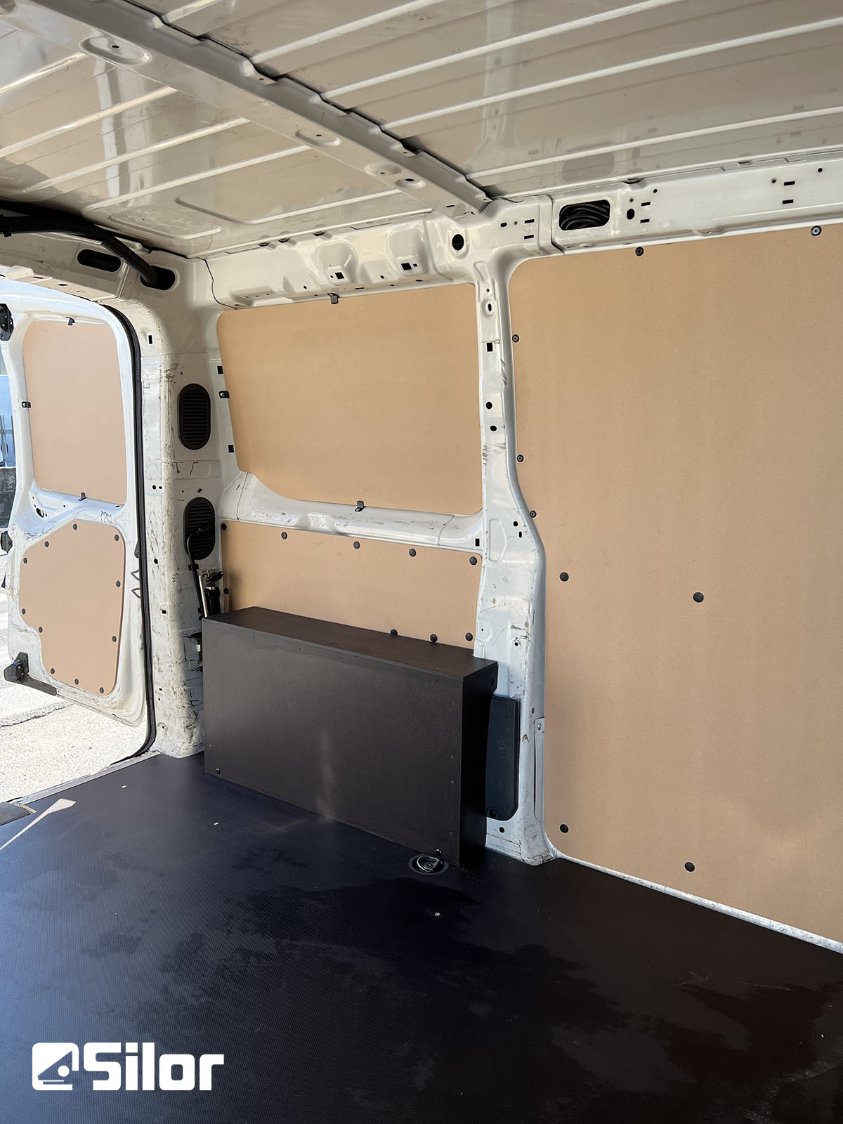 Interni di un furgone con pannelli e pavimento installati.