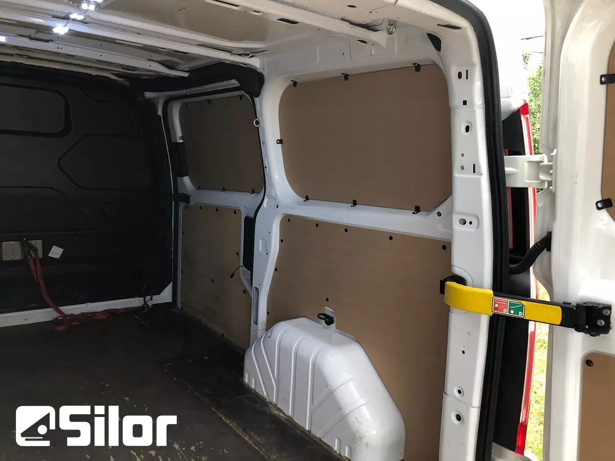 Interni di un furgone bianco con pannelli in legno.