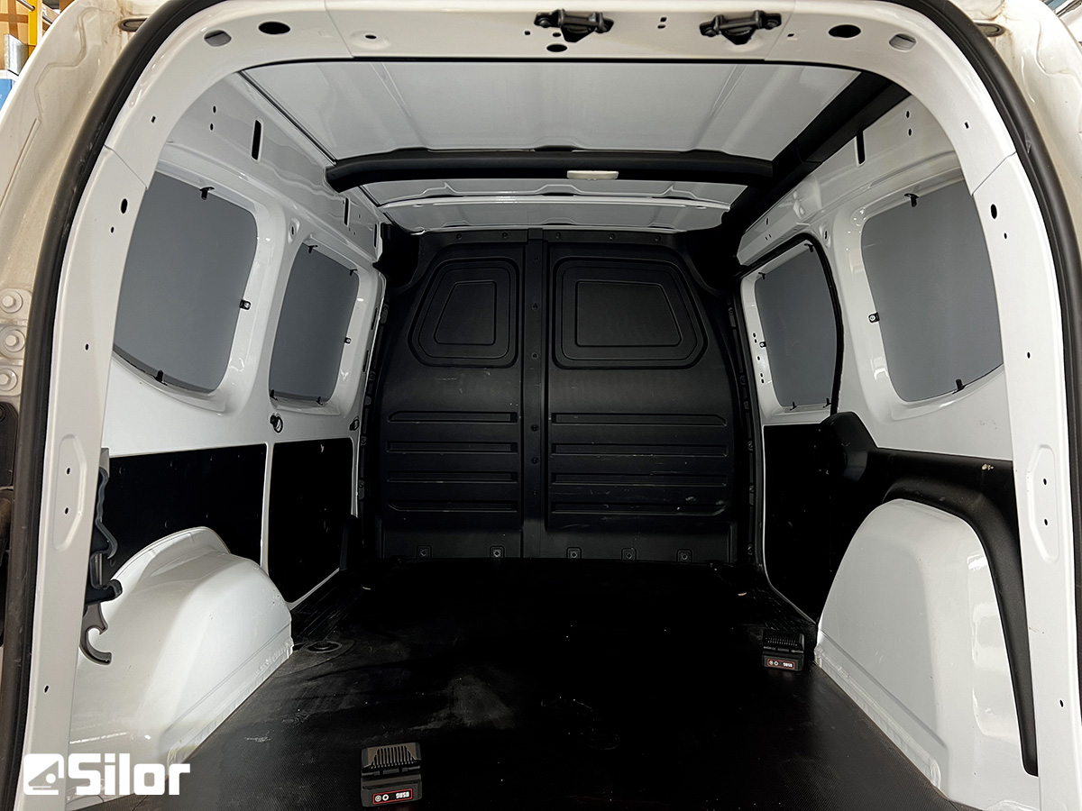 Interno di un furgone bianco con finestre.