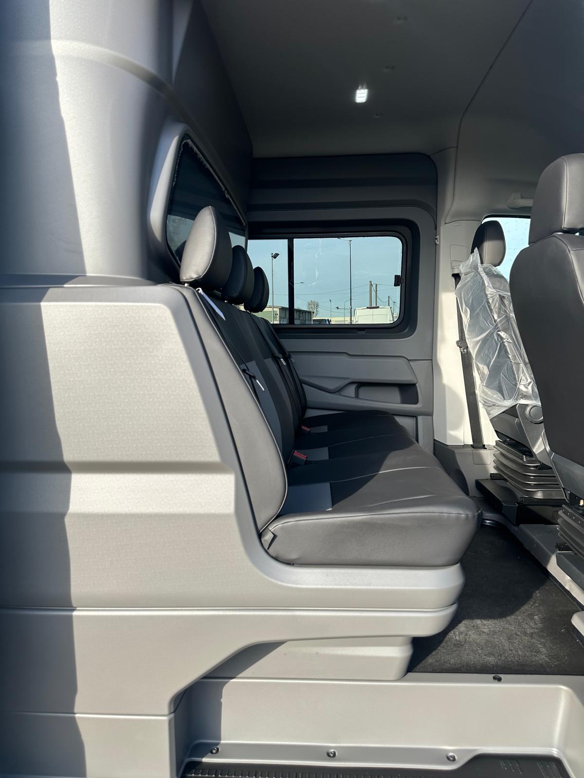 Interni di un veicolo con sedili posteriori e anteriori.