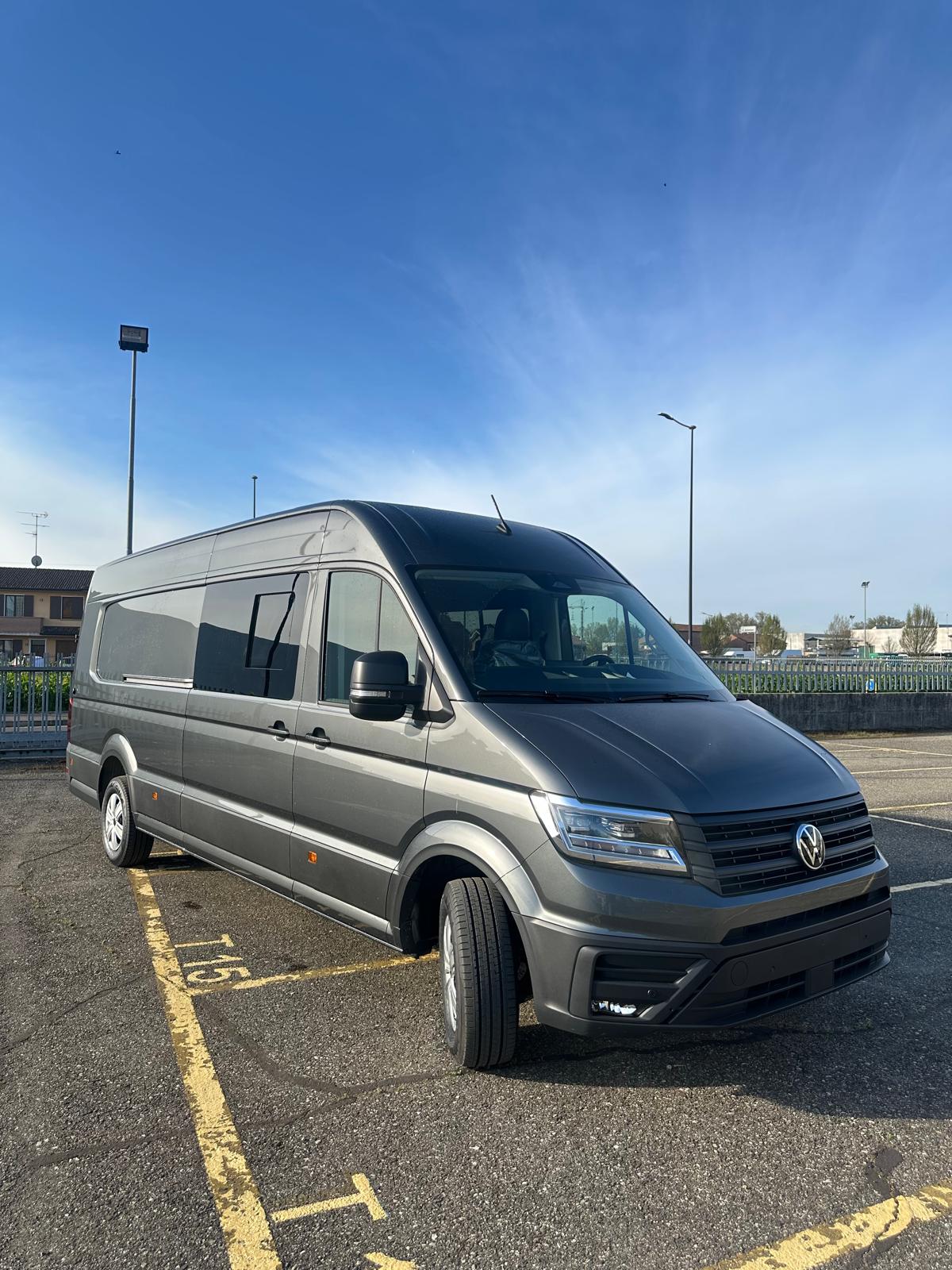 Un furgone Volkswagen grigio parcheggiato in un parcheggio.