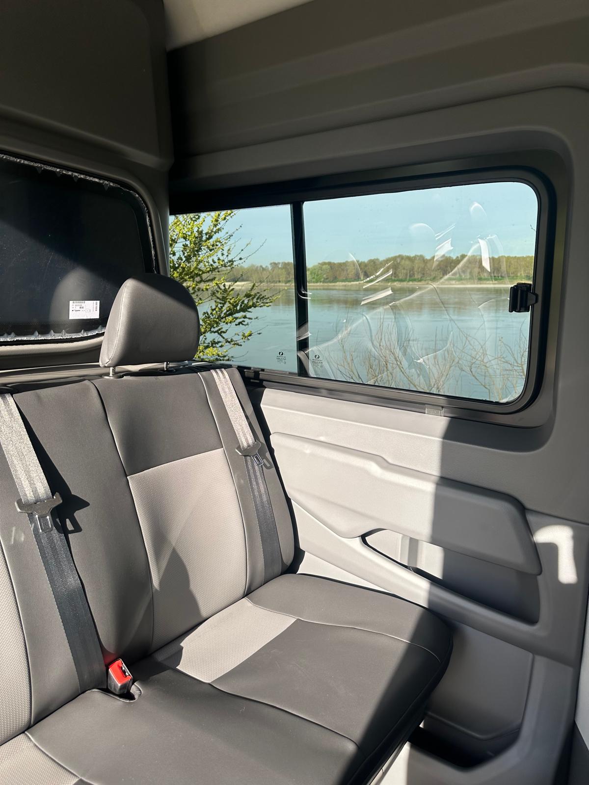 Sedile posteriore in un furgone con vista su un fiume.
