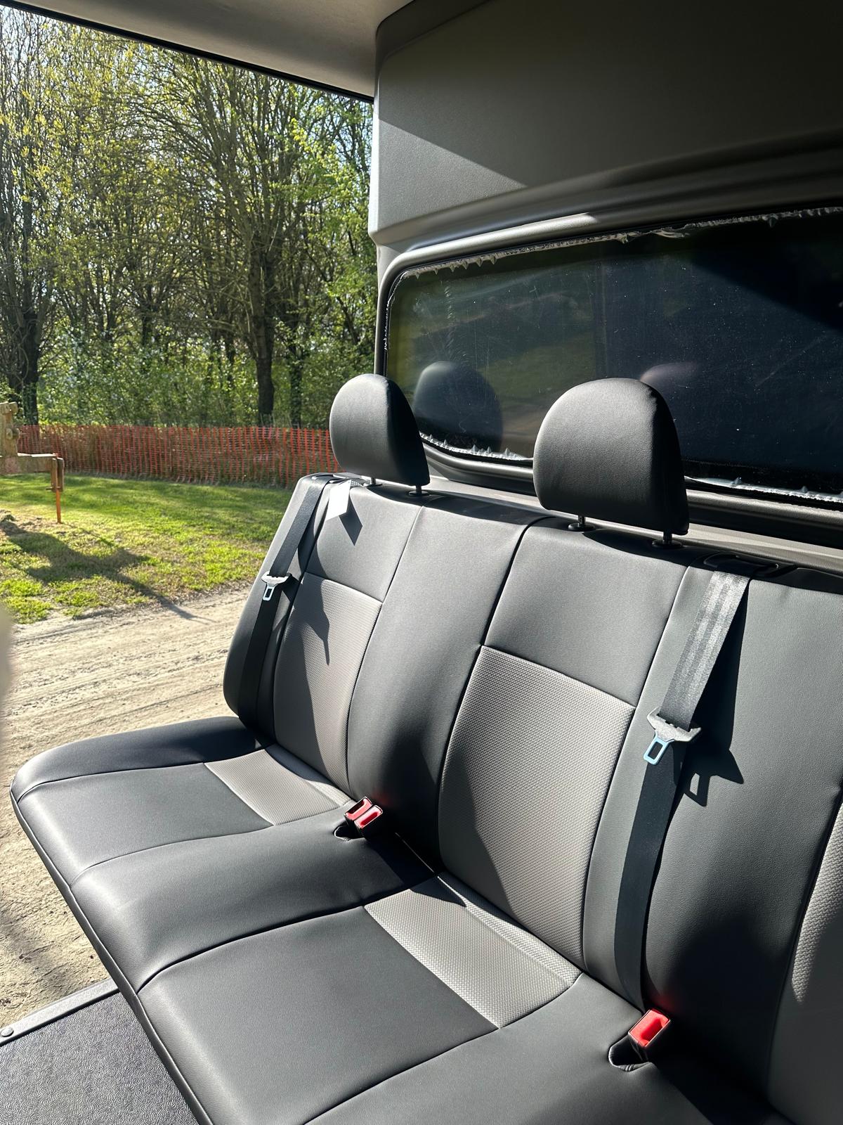 Sedile posteriore grigio in pelle in furgone camperizzato.