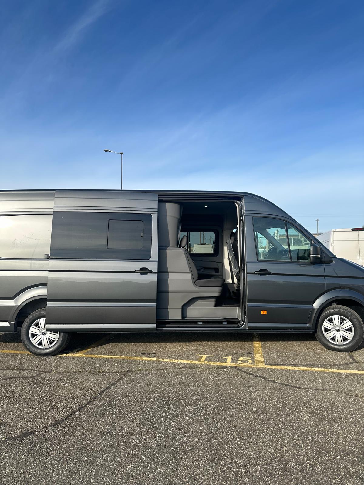 Furgone grigio parcheggiato con portiera scorrevole aperta.