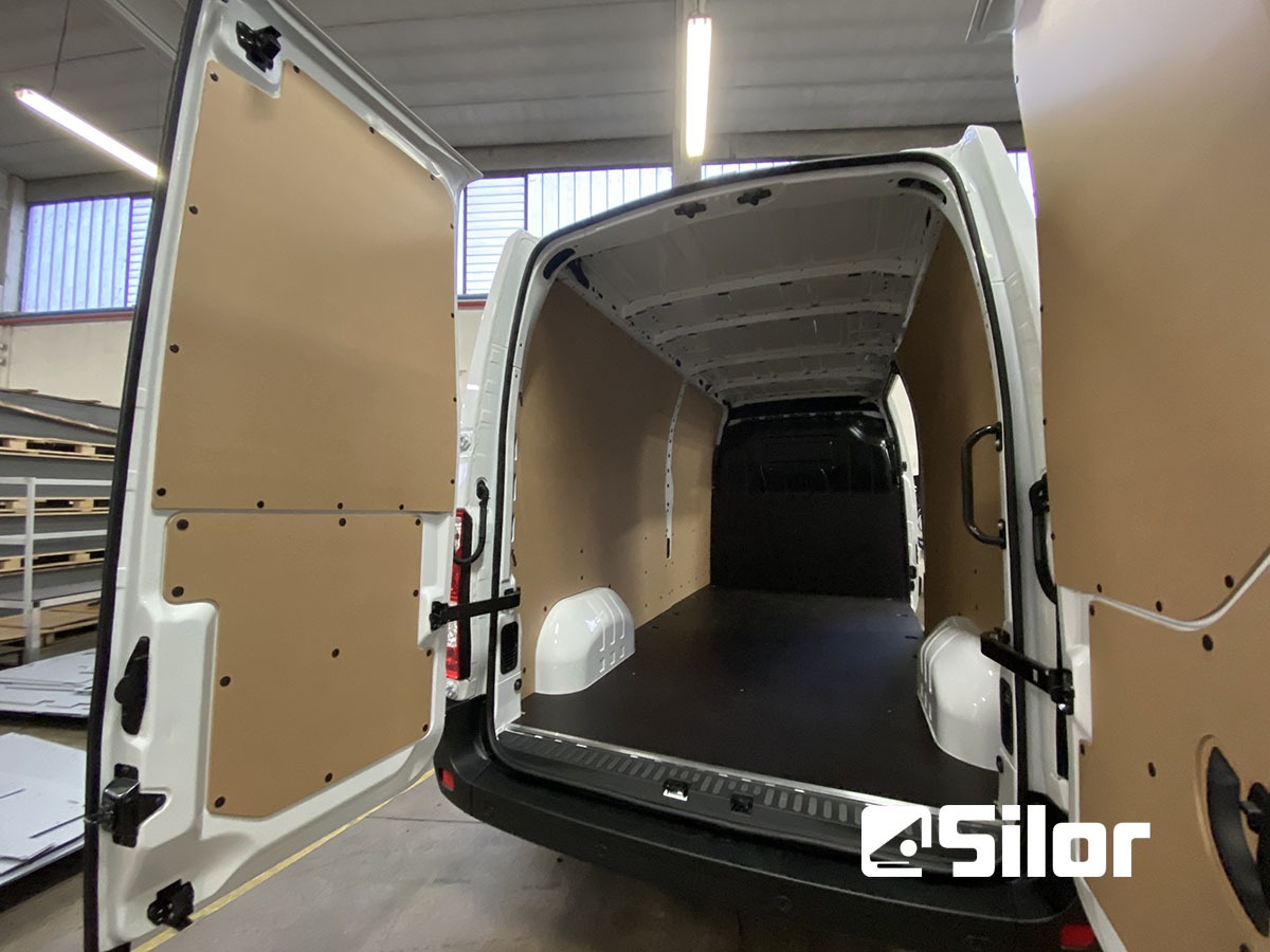 Interno di un furgone bianco con pannelli in legno.