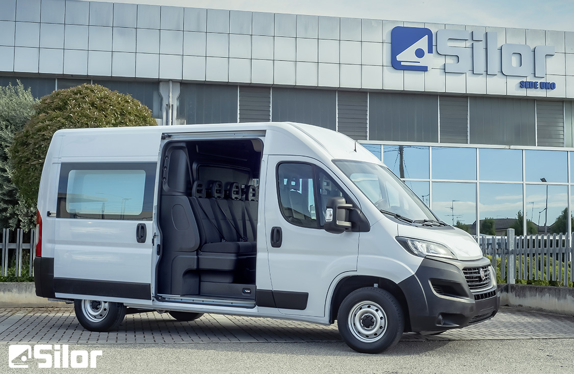 Furgone passeggeri bianco di fronte all'edificio Silor.