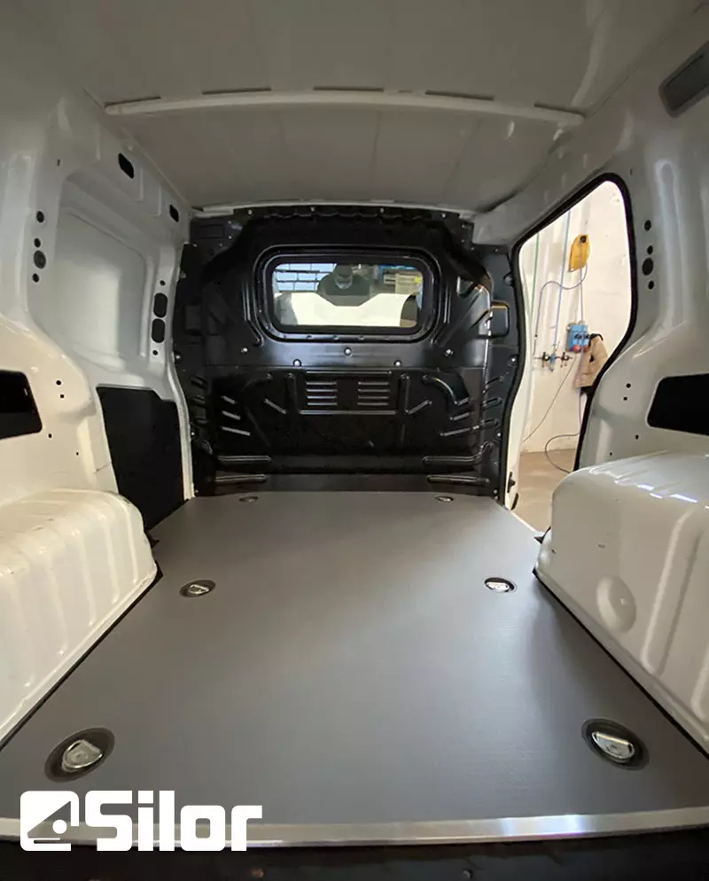 Interni di un furgone merci vuoto e pulito con una pavimentazione grigia.