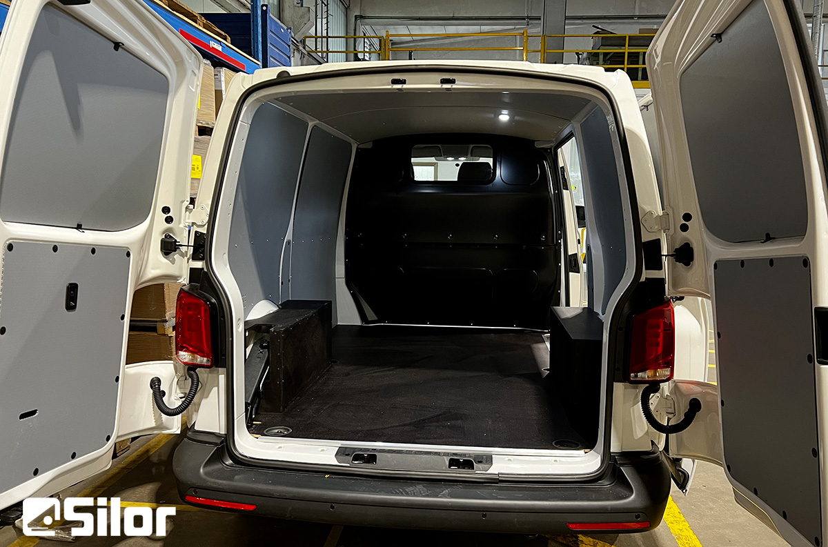 Interno di un furgone bianco con le porte posteriori aperte.
