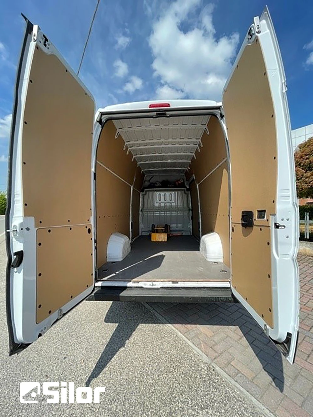Un furgone bianco con le porte posteriori aperte.