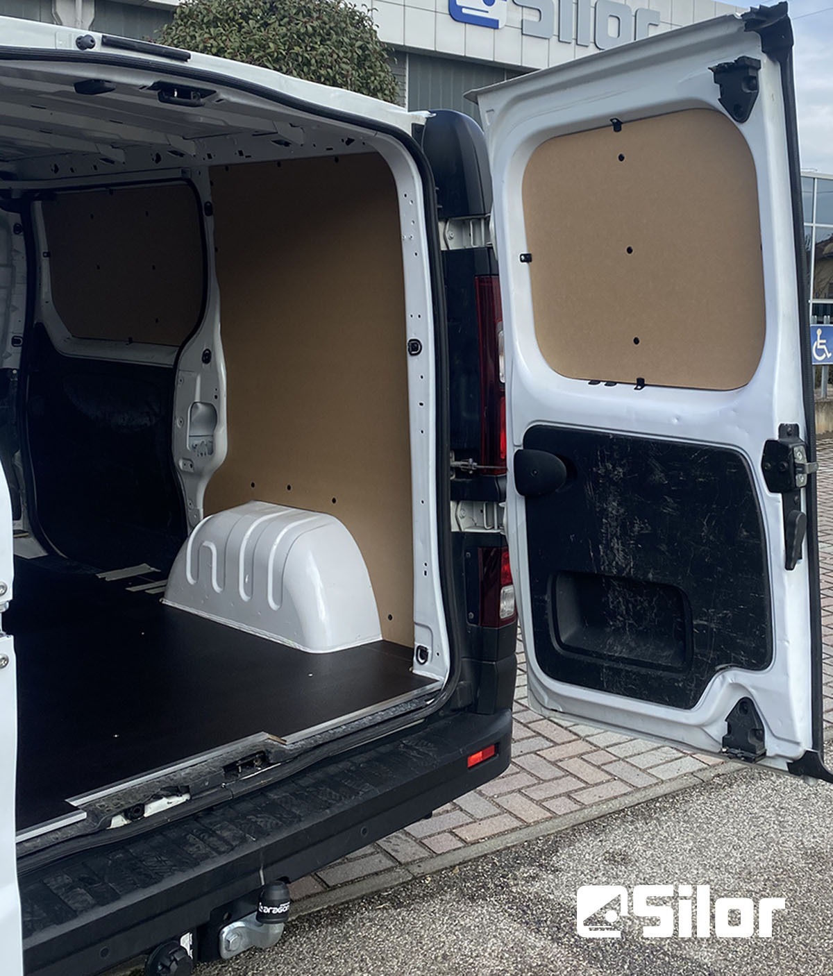 Interno di un furgone bianco con portellone aperto.