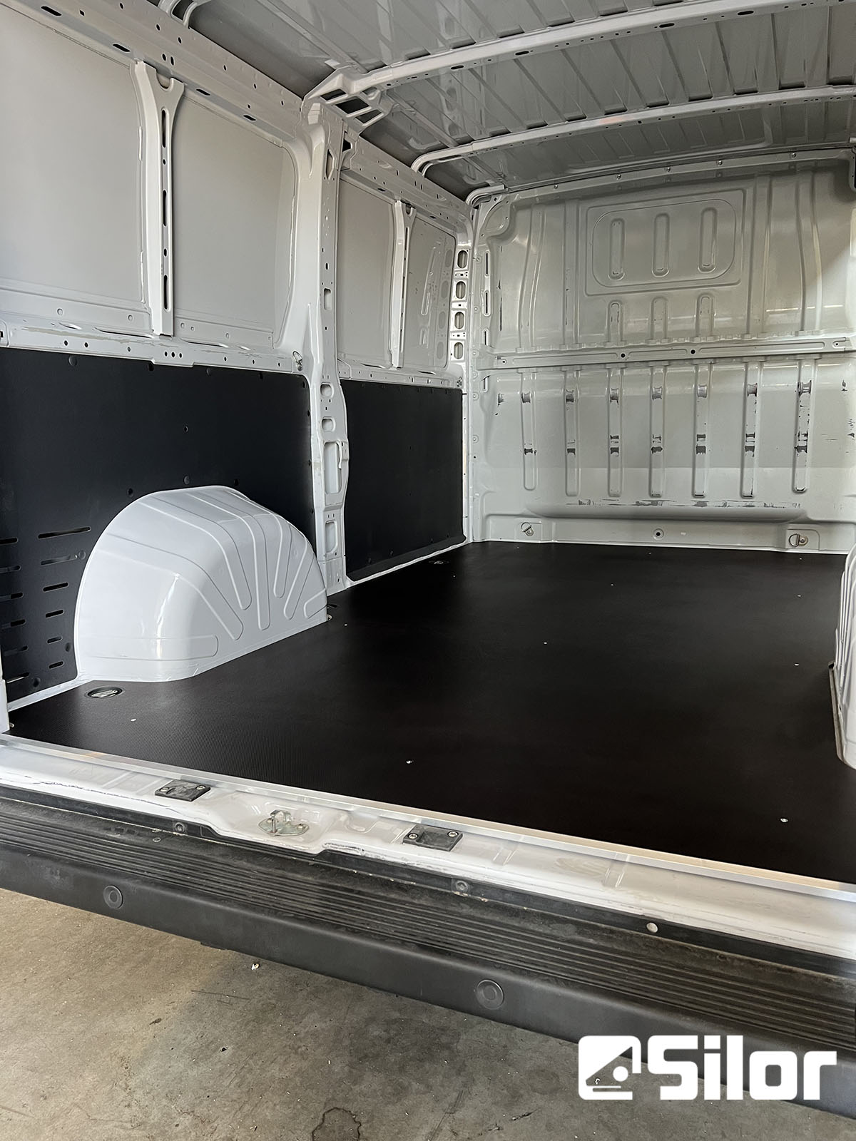 Interni di furgone bianchi con rivestimento nero.
