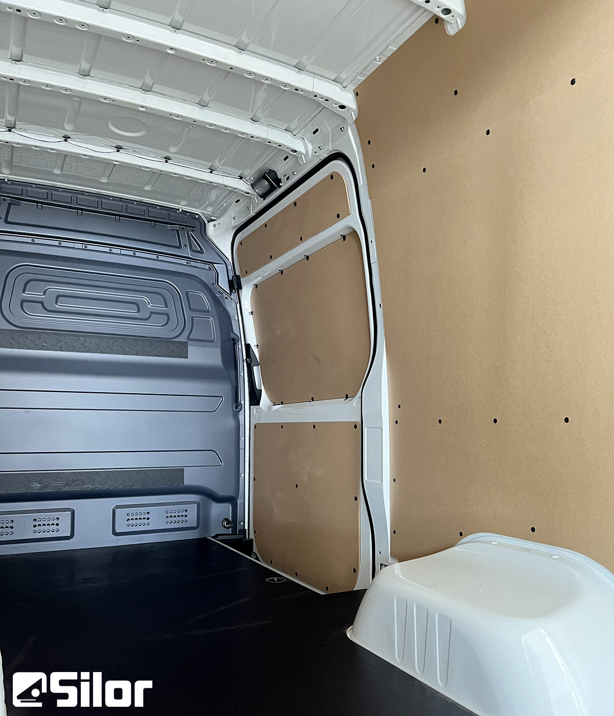 Interni di un furgone bianco con rivestimento in legno.