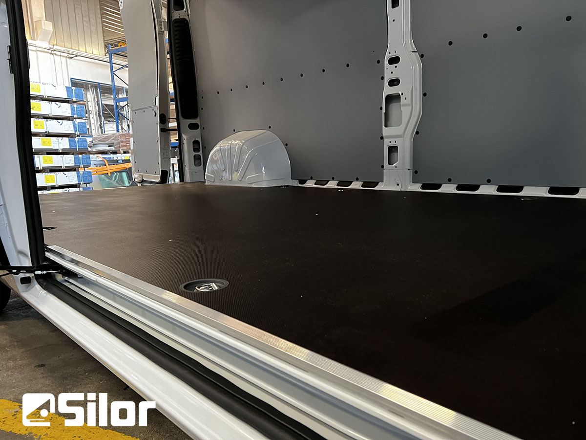 Interni di un furgone bianco con rivestimenti neri.