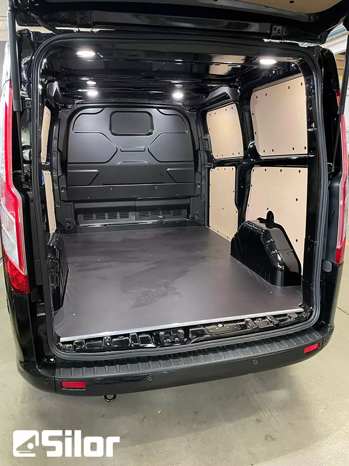 Interni spaziosi e ben illuminati di un furgone nero.