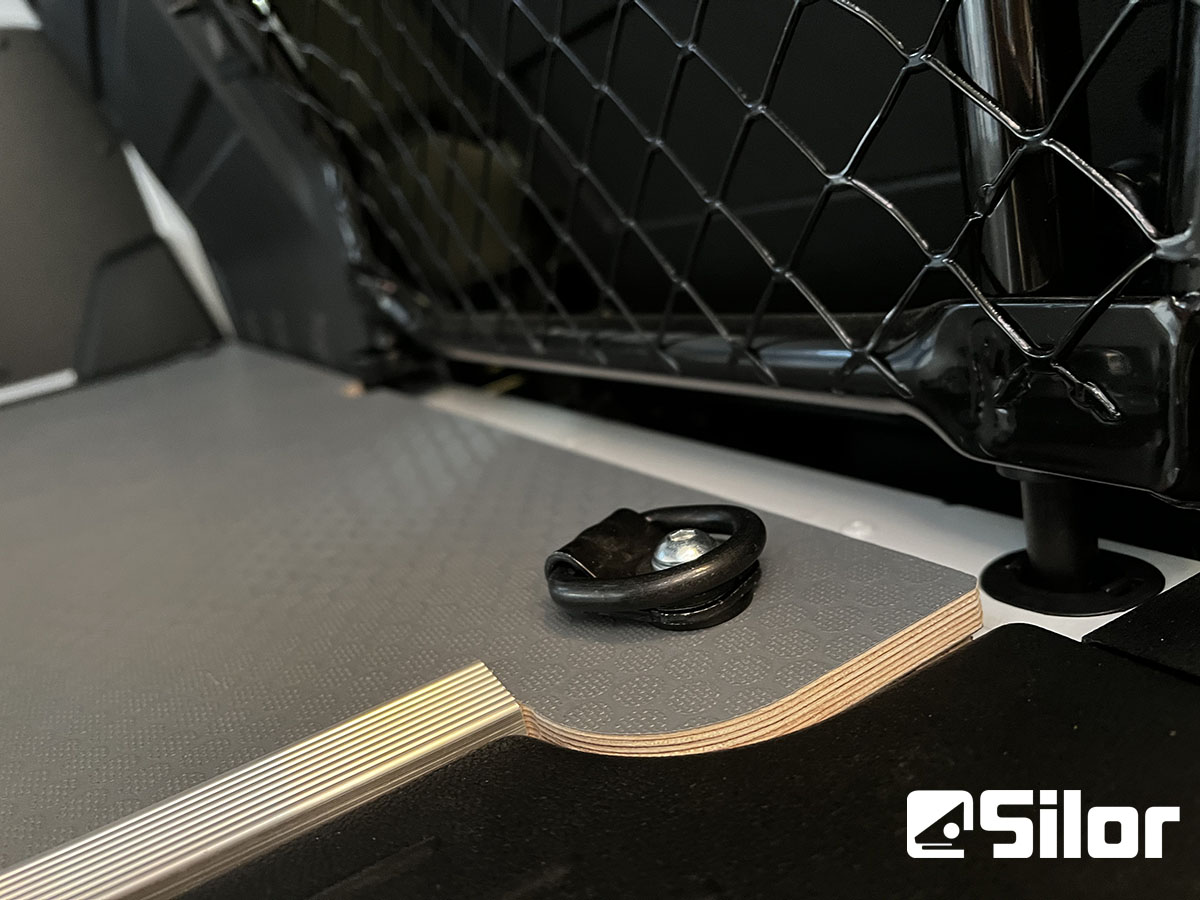 Un anello di ancoraggio fissato a un pavimento in legno personalizzato con logo Silor.